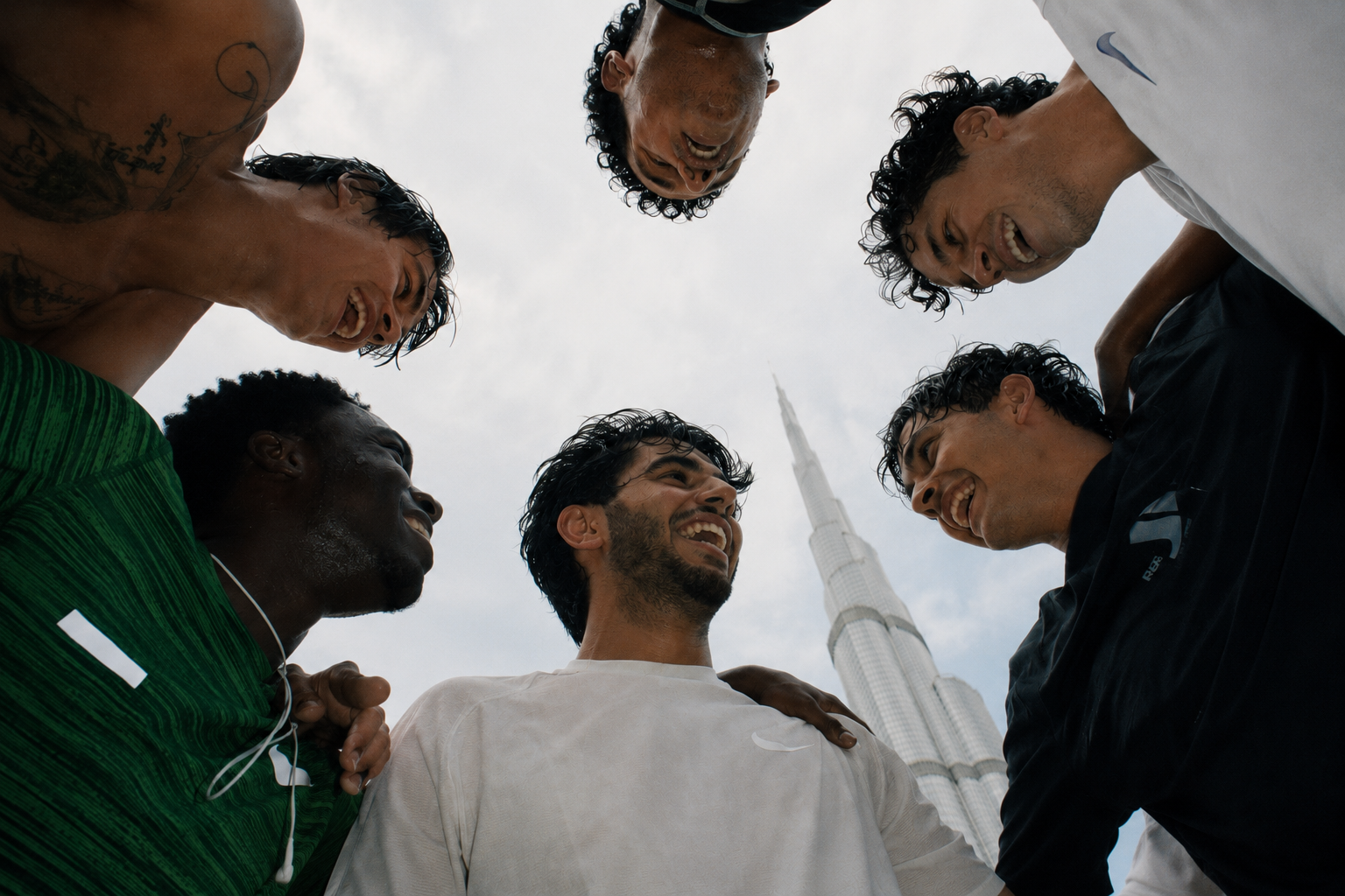 Trainers huddled together with the Burj Khalifa behind them, Dubai